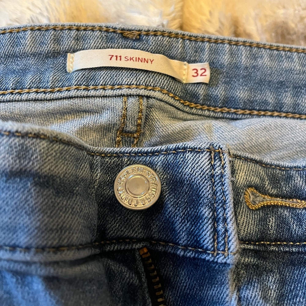 Worn Levi’s 711 women’s skinny distressed jeans size 32.